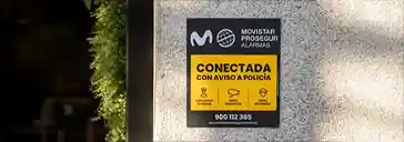 Placa disuasoria «Conectada con aviso a Policía» en la fachada de una vivienda