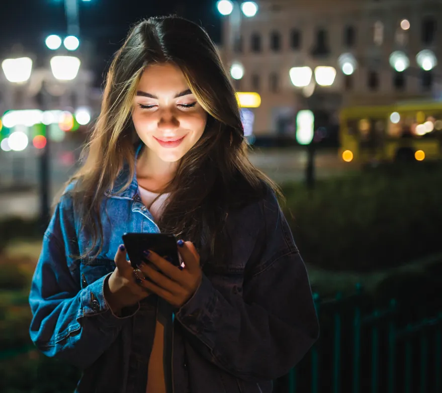 Mujer usando la app de la alarma de noche en la calle